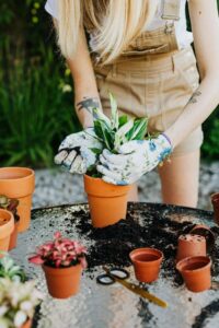 A woman in a red shirt and plaid shirt is gardening